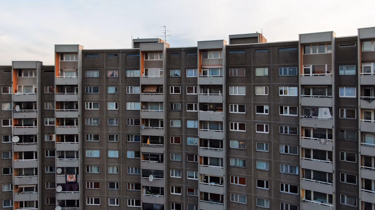 Façade d'un grand immeuble d'habitation collectif, rangées de balcons et de fenêtres sur toute la hauteur
