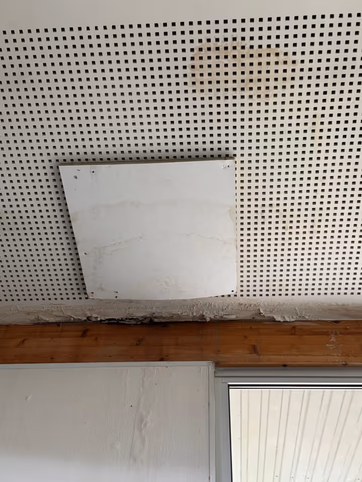 Auréole d'infiltration sur un faux plafond, trappe de visite ouverte
